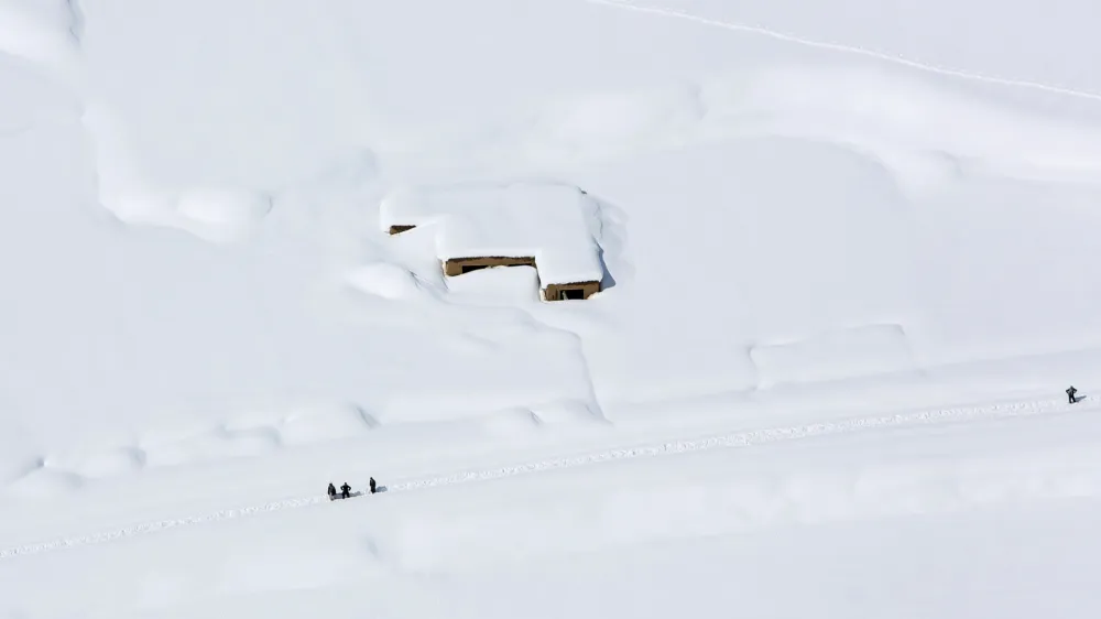 A house is covered with snow from an avalanche in the Paryan district of Panjshir province, north of Kabul, Afghanistan, Friday, Feb. 27, 2015. The death toll from severe weather that caused avalanches and flooding across much of Afghanistan has jumped to more than 200 people, and the number is expected to climb with cold weather and difficult conditions hampering rescue efforts, relief workers and U.N. officials said Friday. (AP Photo/Rahmat Gul)