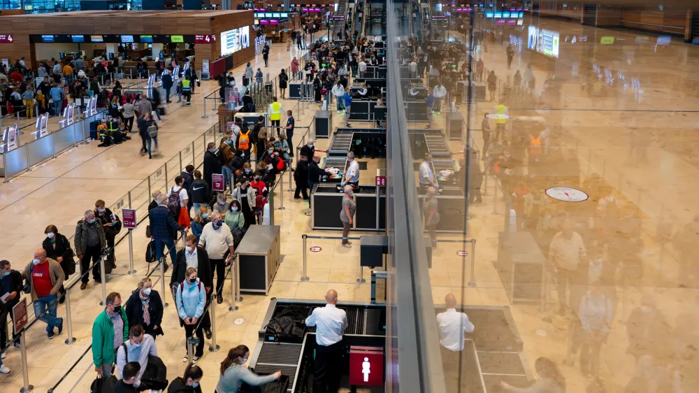 15 October 2021, Brandenburg, Sch&ouml;nefeld: Passengers wait in line in front of the check-in counters in Terminal 1 of Berlin Brandenburg Airport. At the weekend, the capital's airport is expected to see increased passenger traffic due to the autumn holidays. Photo: Monika Skolimowska/dpa-Zentralbild/dpa