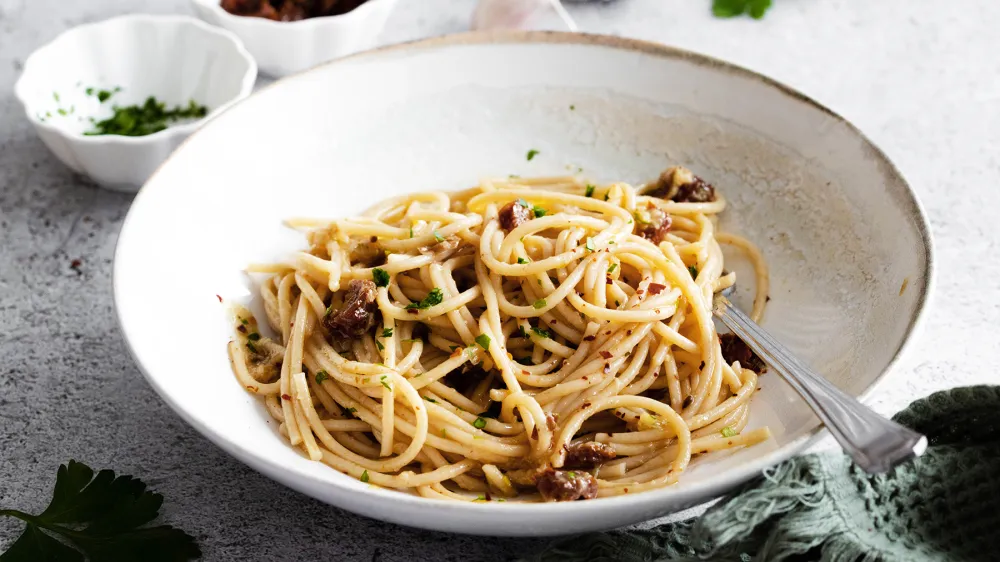 &Scaron;pageti s pečenim česnom in su&scaron;enimi paradižniki