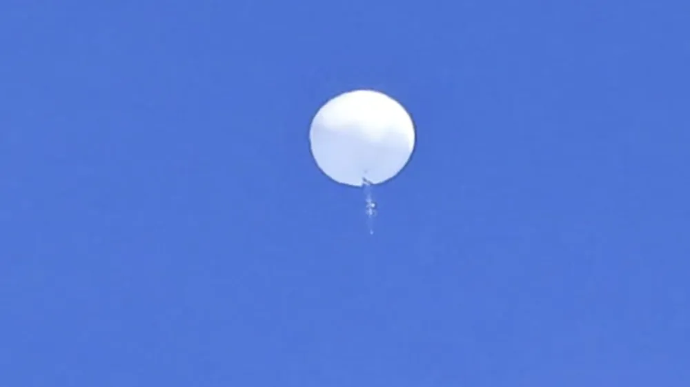 In this photo provided by Travis Huffstetler Photography, a large balloon drifts above the Atlantic Ocean, just off the coast of the Carolinas, Saturday, Feb. 4, 2023. The massive white orb that drifted across U.S. airspace this week and was shot down by the Air Force over the Atlantic on live television Saturday triggered a diplomatic maelstrom and blew up on social media. (Travis Huffstetler Photography via AP)