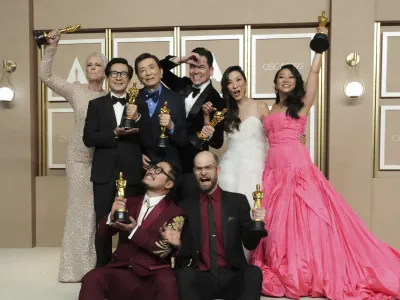 Jamie Lee Curtis, from back left, Ke Huy Quan, James Hong, Jonathan Wang, Michelle Yeoh, and Stephanie Hsu, Daniel Kwan, left front, and Daniel Scheinert, winners of the award for best film for "Everything Everywhere All at Once," pose in the press room at the Oscars on Sunday, March 12, 2023, at the Dolby Theatre in Los Angeles. (Photo by Jordan Strauss/Invision/AP)