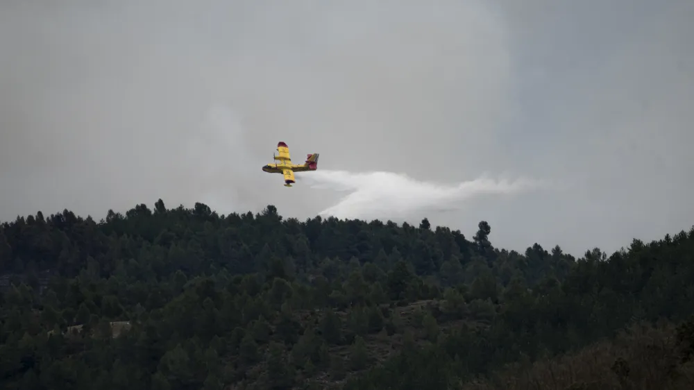 24 March 2023, Spain, San Agustin: A helicopter flies over San Agustin to help in extinguishing the forest fire. The forest fire advanced without control after burning 800 hectares and forcing the evacuation of eight municipalities and districts. Photo: Lorena Sop&ecirc;na/EUROPA PRESS/dpa