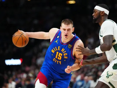 Mar 25, 2023; Denver, Colorado, USA; Denver Nuggets center Nikola Jokic (15) drives at Milwaukee Bucks forward Bobby Portis (9) during the second half at Ball Arena. Mandatory Credit: Ron Chenoy-USA TODAY Sports