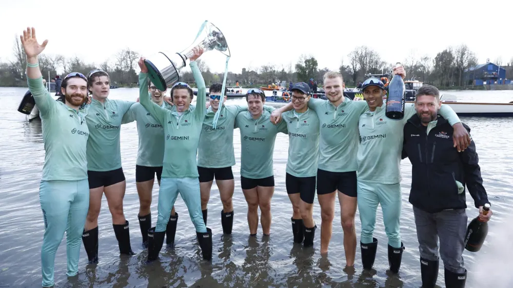Rowing - University Boat Race - Oxford v Cambridge - River Thames, London, Britain - March 26, 2023 Cambridge coxswain Jasper Parish celebrates with the trophy and teammates after winning the men's race Action Images via Reuters/Andrew Boyers