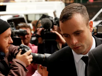 FILE PHOTO: Olympic and Paralympic track star Oscar Pistorius (R) arrives ahead of his trial for the murder of his girlfriend Reeva Steenkamp, at the North Gauteng High Court in Pretoria April 16, 2014. REUTERS/Siphiwe Sibeko/File Photo