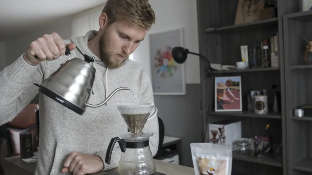 Med pogovorom Žiga Pov&scaron;e pripravi kavo iz zrn kave, ki so jih vzgojili na kmetiji Andressine družine.