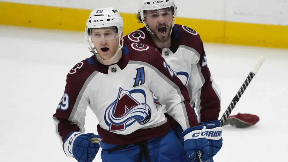 Colorado Avalanche center Nathan MacKinnon (29) celebrates with Samuel Girard (49) after MacKinnon scored against the Nashville Predators during the third period of an NHL hockey game Friday, April 14, 2023, in Nashville, Tenn. The Avalanche won 4-3. (AP Photo/Mark Humphrey)