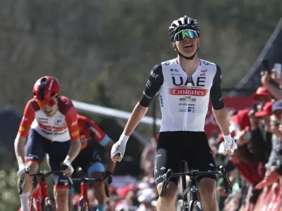 Slovenia's Tadej Pogacar of the UAE Team Emirates, right, crosses the finish line to win the Belgian cycling classic and UCI World Tour race Fleche Wallonne (Walloon Arrow), in Huy, Belgium, Wednesday, April 19, 2023. (AP Photo/Geert Vanden Wijngaert)