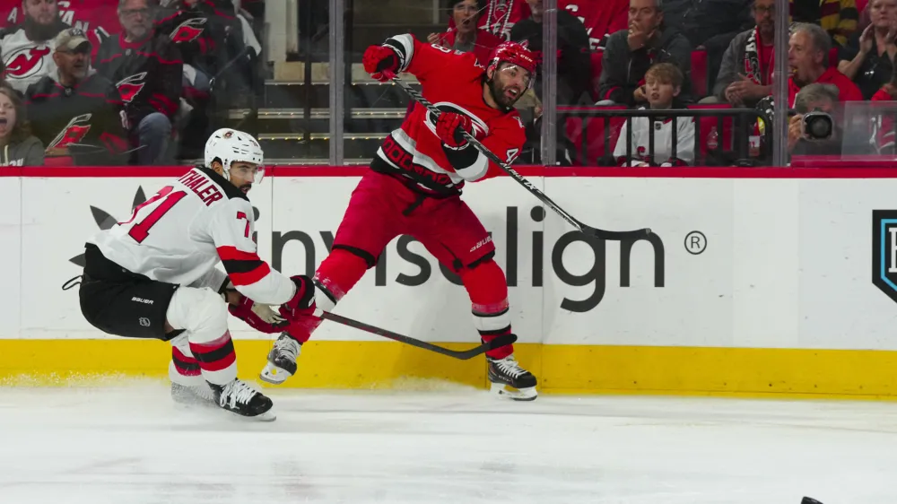May 5, 2023; Raleigh, North Carolina, USA; Carolina Hurricanes left wing Jordan Martinook (48) takes a shot against New Jersey Devils defenseman Jonas Siegenthaler (71) during the first period in game two of the second round of the 2023 Stanley Cup Playoffs at PNC Arena. Mandatory Credit: James Guillory-USA TODAY Sports