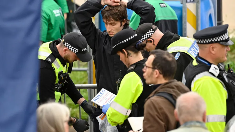 Protesters from climate protest group 'Just Stop Oil' are apprehended by police officers in the crowd close to where Britain's King Charles III and Britain's Camilla, Queen Consort will be crowned at Westminster Abbey in central London on May 6, 2023. - The set-piece coronation is the first in Britain in 70 years, and only the second in history to be televised. Charles will be the 40th reigning monarch to be crowned at the central London church since King William I in 1066.   JUSTIN TALLIS/Pool via REUTERS