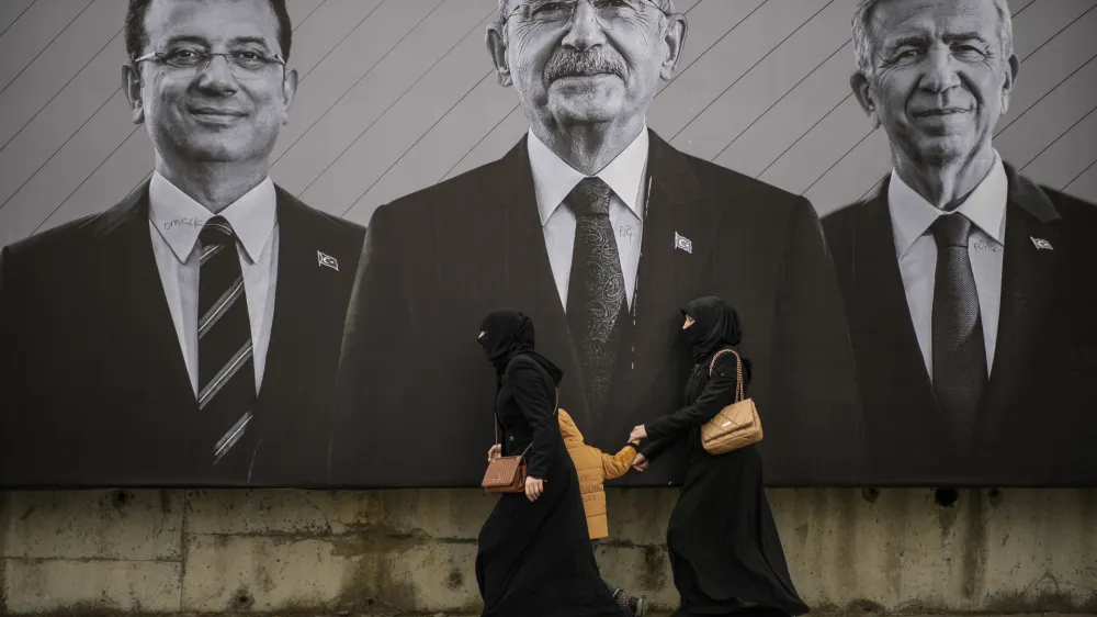 People walk past an election campaign billboard of Republican People's Party presidential candidate Kemal Kilicdaroglu, center, Istanbul Mayor Ekrem Imamoglu, left, and Ankara Mayor Mansur Yavas ahead of the May 14 presidential and parliamentary elections, in Istanbul, Turkey, Saturday, May 6, 2023. (AP Photo/Emrah Gurel)