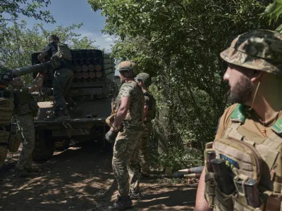 Ukrainian soldiers load rockets into a Grad multiple rocket launcher to fire towards Russian positions in the frontline near Bakhmut, Donetsk region, Ukraine, Wednesday, May 17, 2023. (AP Photo/Libkos)