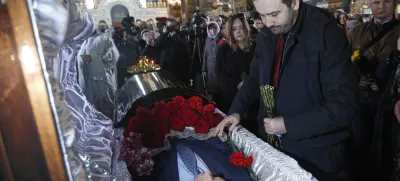 Ilya Ponomarev,a fugitive Russian lawmaker, pays respects for slain former Russian lawmaker Denis Voronenkov during his funeral service, at St. Volodymyr Cathedral in Kiev, Ukraine, Saturday, March 25, 2017. A Ukrainian official said Friday that the killer of Voronenkov, who was gunned down in the Ukrainian capital of Kiev, was a Russian agent, a claim quickly rejected by the Kremlin. (e to Ukraine, was shot dead near the entrance of an upscale hotel in the center of the Ukrainian capital on Thursday. He was wanted on criminal charges in Russia. (AP Photo/Sergei Chuzavkov)
