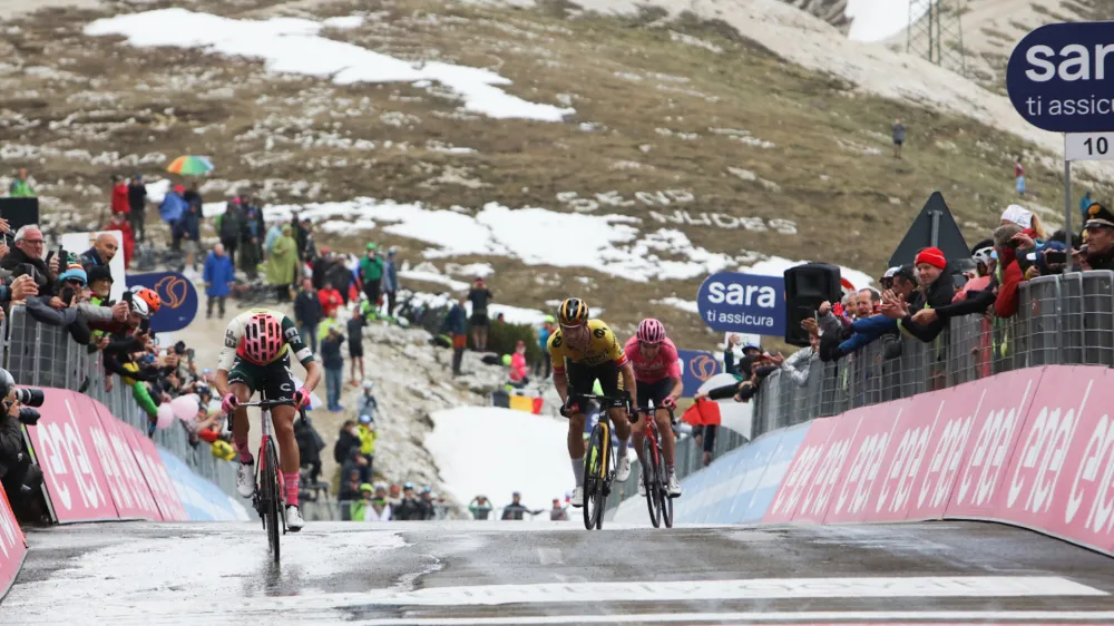 Primož Roglič (v sredini) je tik pred ciljno črto dana&scaron;nje etape ukradel tri sekunde nosilcu rožnate majice, Valižanu Geraintu Thomasu (desno).