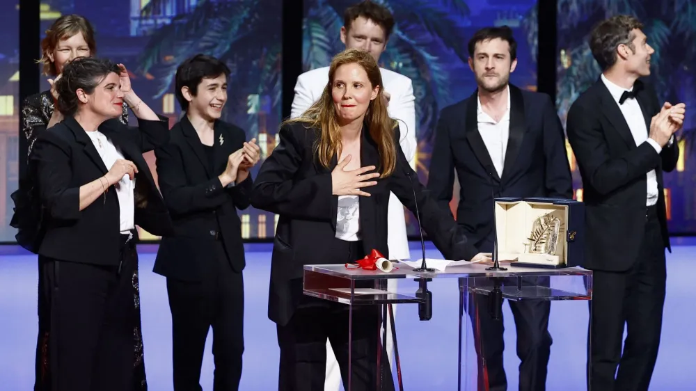 Director Justine Triet, Palme d'Or award winner for the film "Anatomie d'une chute" (Anatomy of a Fall), reacts next to team on stage during the closing ceremony of the 76th Cannes Film Festival in Cannes, France, May 27, 2023. REUTERS/Eric Gaillard