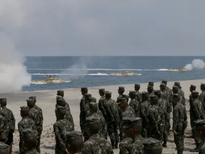 Philippine Marines watch U.S. Navy amphibious assault vehicles storm the beach during a combined assault exercise facing one of the contested islands in the South China Sea known as the Scarborough Shoal in the West Philippine Sea Tuesday, April 21, 2015 at the Naval Education and Training Command at San Antonio township, Zambales province, northwest of Manila, Philippines. More than ten thousand troops from both the U.S. and Philippine militaries are taking part in the annual military drill that focuses on regional security, terrorism, disaster preparedness and inter-operability of both countries. (AP Photo/Bullit Marquez)