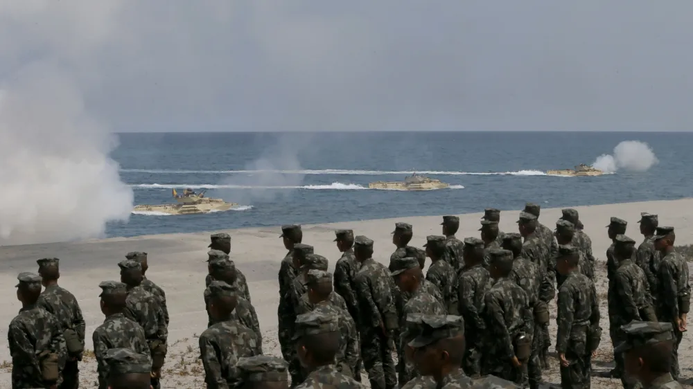 Philippine Marines watch U.S. Navy amphibious assault vehicles storm the beach during a combined assault exercise facing one of the contested islands in the South China Sea known as the Scarborough Shoal in the West Philippine Sea Tuesday, April 21, 2015 at the Naval Education and Training Command at San Antonio township, Zambales province, northwest of Manila, Philippines. More than ten thousand troops from both the U.S. and Philippine militaries are taking part in the annual military drill that focuses on regional security, terrorism, disaster preparedness and inter-operability of both countries. (AP Photo/Bullit Marquez)