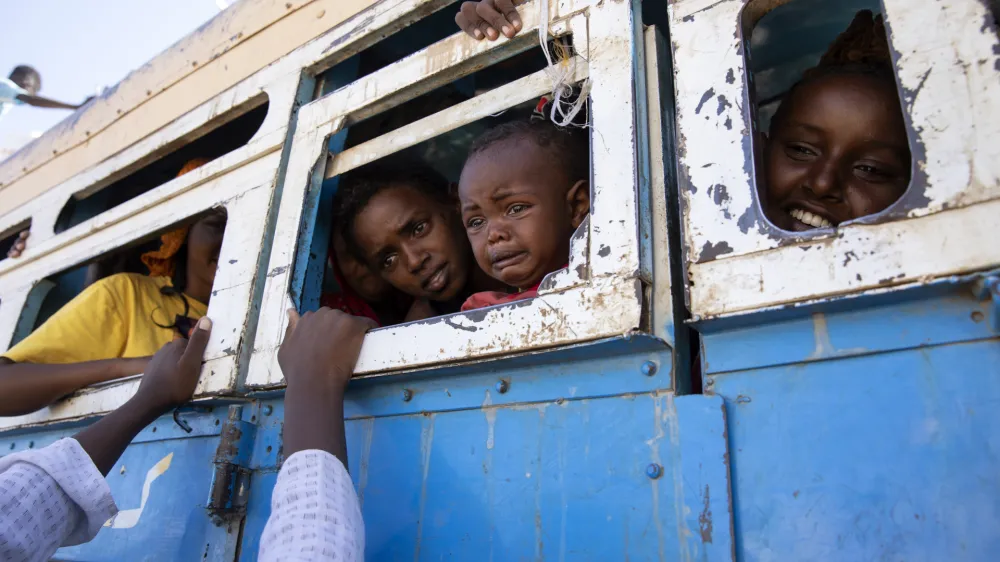 Refugees who fled the conflict in Ethiopia's Tigray region ride a bus going to the Village 8 temporary shelter, near the Sudan-Ethiopia border, in Hamdayet, eastern Sudan, on Dec. 1, 2020. (AP Photo/Nariman El-Mofty)