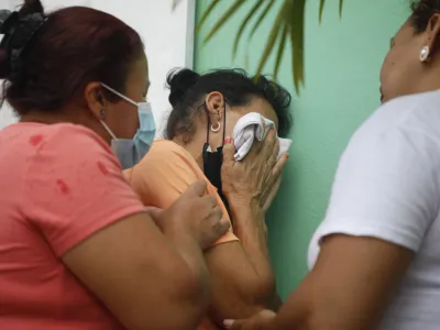 Family members wait in distress outside the entrance to the women's prison in Tamara, on the outskirts of Tegucigalpa, Honduras, Tuesday, June 20, 2023. A riot at the women's prison northwest of the Honduran capital has left at least 41 inmates dead, most of them burned to death, a Honduran police official said. (AP Photo/Elmer Martinez)