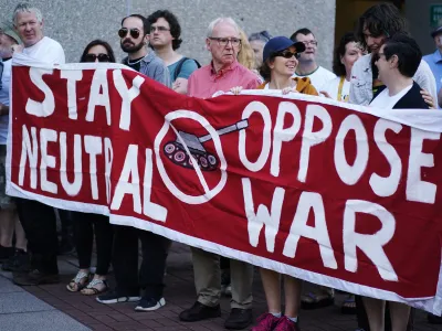 22 June 2023, Ireland, Cork: Protesters at University College Cork hold a banner during a protest ahead of the Consultative Forum on International Security Policy. Photo: Brian Lawless/PA Wire/dpa