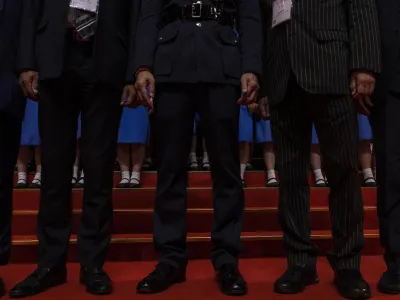 Disciplined Services officials pose with students during a ceremony to mark the 26th anniversary of Hong Kong's return to Chinese rule&nbsp; in Hong Kong, Saturday, July 1, 2023. (AP Photo/Louise Delmotte)