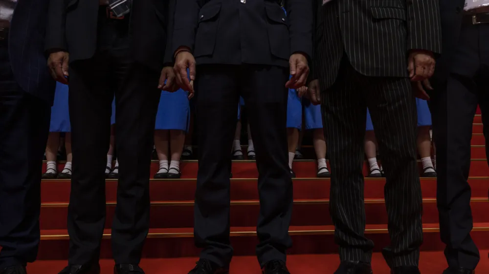 Disciplined Services officials pose with students during a ceremony to mark the 26th anniversary of Hong Kong's return to Chinese rule&nbsp; in Hong Kong, Saturday, July 1, 2023. (AP Photo/Louise Delmotte)