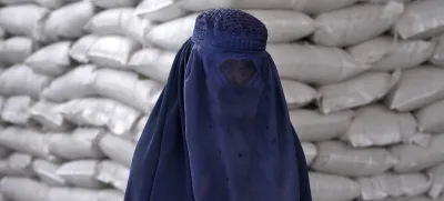 FILE - An Afghan woman waits to receive a food ration distributed by a South Korean humanitarian aid group, in Kabul, Afghanistan, May 10, 2022. (AP Photo/Ebrahim Noroozi, File)