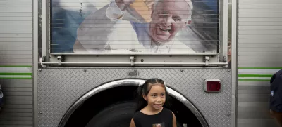 Valentina Fernandez poses for a picture holding an image of Pope Francis after a Mass to pray for his health at Constitution Square in Buenos Aires, Argentina, Monday, Feb. 24, 2025. (AP Photo/Natacha Pisarenko)