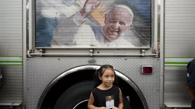 Valentina Fernandez poses for a picture holding an image of Pope Francis after a Mass to pray for his health at Constitution Square in Buenos Aires, Argentina, Monday, Feb. 24, 2025. (AP Photo/Natacha Pisarenko)