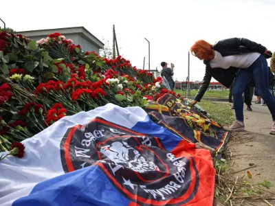 Ženska polaga cvetje v Sankt Peterburgu, enem od ruskih mest, kjer so se na ta način spomnili Jevgenija Prigožina. Foto: Reuters