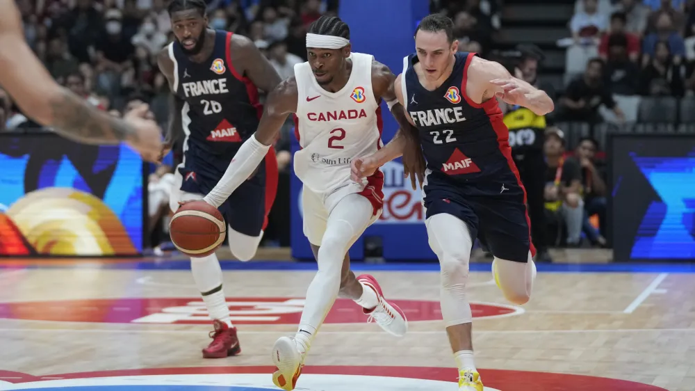 Canada guard Shai Gilgeous-Alexander (2) passes around France forward Terry Tarpey (22) during the Basketball World Cup group H match between France and Canada at the Indonesia Arena stadium in Jakarta, Indonesia, Friday, Aug. 25, 2023. (AP Photo/Dita Alangkara)