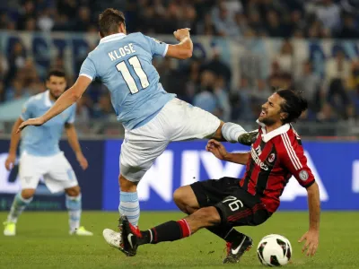 AC Milan's Mario Yepes (R) fights for the ball against Lazio's Miroslav Klose during their Italian Serie A soccer match at Olympic stadium in Rome, October 20, 2012. REUTERS/Stefano Rellandini (ITALY - Tags: SPORT SOCCER)