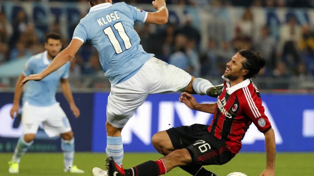 AC Milan's Mario Yepes (R) fights for the ball against Lazio's Miroslav Klose during their Italian Serie A soccer match at Olympic stadium in Rome, October 20, 2012. REUTERS/Stefano Rellandini (ITALY - Tags: SPORT SOCCER)