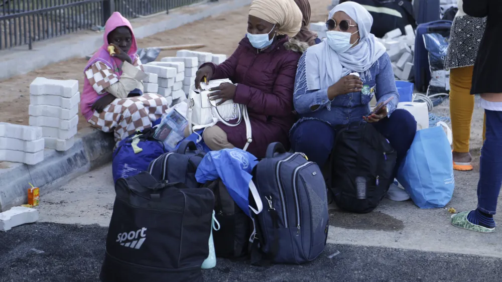 Migrants wait to board a flight in Misrata, Libya, Monday, Oct. 24, 2022. The Libyan authorities, in cooperation with the International Organization for Migration (IOM), repatriated 141 Nigerian migrants from the city of Misrata on Monday, as part of a program to resume voluntary flights to deport migrants. (AP Photo/Yousef Murad)