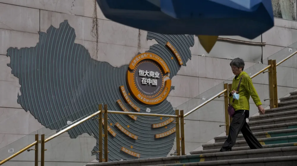 A woman walks by a map showing Evergrande development projects in China, as she heads to an Evergrande city plaza in Beijing, Monday, Sept. 18, 2023. Police in a southern Chinese city said on last Saturday they have detained some staff at China Evergrande Group's wealth management unit in the latest trouble for the heavily indebted developer. (AP Photo/Andy Wong)