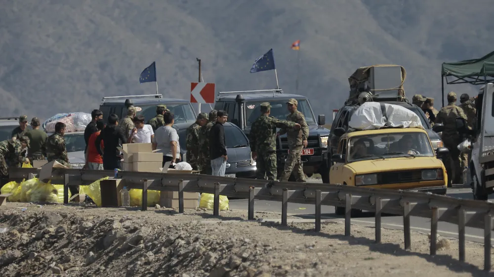 Ethnic Armenians from Nagorno-Karabakh and European Union observers drive their cars past a check point on the road from Nagorno-Karabakh to Armenia's Goris in Syunik region, Armenia, Friday, Sept. 29, 2023. Armenian officials say more than 70% of Nagorno-Karabakh's original population have fled the region for Armenia. (AP Photo/Vasily Krestyaninov)
