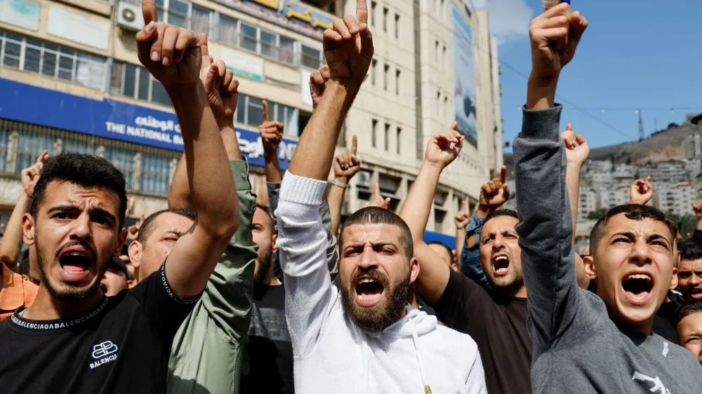 Palestinci na Zahodnem bregu protestirajo zaradi bombardiranja bolni&scaron;nice v Gazi, za kar obtožujejo Izrael, in nasploh zaradi razmer v palestinski enklavi. Protesti so sicer danes potekali po vsem svetu, od Tokia in Džakarte do Latinske Amerike. Foto: AP