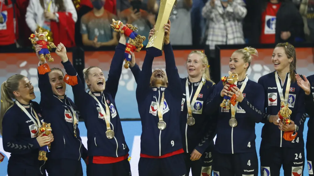 Norway's Mora Mork lifts the trophy as team players celebrate after beating France during the final of the Women's Handball World Championship in Granollers, Spain, Sunday, Dec. 19, 2021. (AP Photo/Joan Monfort)