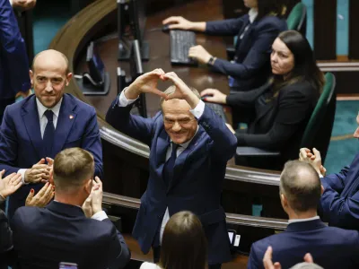 Donald Tusk shows a heart with his hands to lawmakers after he was elected as Poland's Prime Minister at the parliament in Warsaw, Poland, Monday Dec. 11, 2023. (AP Photo/Michal Dyjuk)