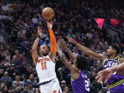 Dec 13, 2023; Salt Lake City, Utah, USA; New York Knicks guard Jalen Brunson (11) shoots the ball over Utah Jazz guard Collin Sexton (2) and guard Ochai Agbaji (30) during the second quarter at Delta Center. Mandatory Credit: Rob Gray-USA TODAY Sports