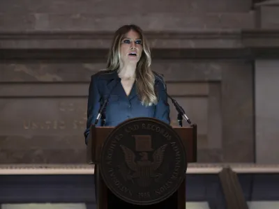 Former first lady Melania Trump welcomes newly-sworn American citizens as the National Archives holds a naturalization ceremony with 25 people from 25 nations, in Washington, Friday, Dec. 15, 2023. A naturalized citizen herself, Melania Trump, wife of former President Donald Trump, was originally from Slovenia. The event is part of the Archives' annual celebration of Bill of Rights Day. (AP Photo/J. Scott Applewhite)