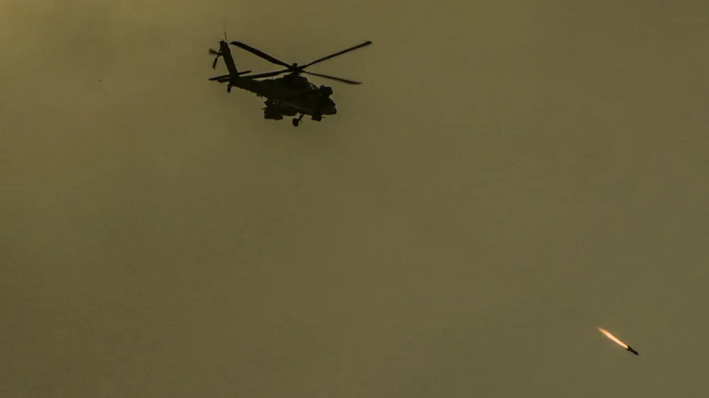 An Israeli Apache helicopter fires a missile in direction of the Gaza Strip, as seen from southern Israel, Friday, Dec. 29, 2023. The army is battling Palestinian militants across Gaza in the war ignited by Hamas' Oct. 7 attack into Israel. (AP Photo/Ariel Schalit)