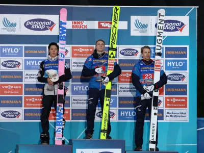 Ski Jumping - 4 Hills Tournament - Innsbruck, Austria - January 3, 2024 Austria's Jan Hoerl celebrates with the trophy on the podium after winning along with second placed Japan's Ryoyu Kobayashi and third placed Austria's Michael Hayboeck REUTERS/Kai Pfaffenbach