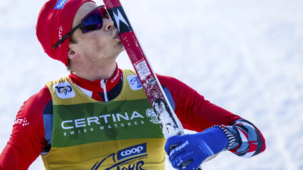 The winner Harald Oestberg Amundsen of Norway celebrates as he crosses the finish line during the men's 20km classic pursuit race of the fifth stage of the Tour de Ski, in Davos, Switzerland, Thursday, Jan. 4, 2024. (Gian Ehrenzeller/Keystone via AP)