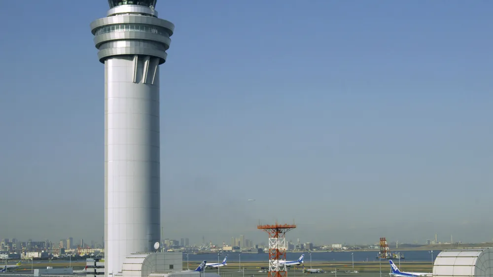 This shows an airport traffic control tower at Haneda airport in Tokyo, on Jan. 9, 2010. The 379 passengers of Japan Airlines Flight JAL-516 didn't expect their plane to burst into flames just as it was about to touchdown at Tokyo's Haneda airport Tuesday evening, on Jan. 2, 2024. A smaller coast guard Bombardier Dash-8 aircraft, preparing to take off to deliver urgent aid to quake-hit central Japan, was using the same runway when the two collided. The Associated Press collected accounts from witnesses, officials and transcripts of the traffic controls communication. (Kyodo News via AP)