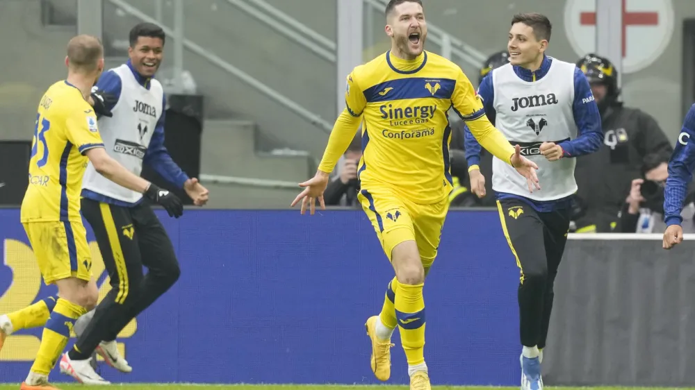 Verona's Thomas Henry, centre, celebrates after scoring his side's first goal during the Serie A soccer match between Inter Milan and Hellas Verona at the San Siro Stadium in Milan, Italy, Saturday, Jan. 6, 2024. (AP Photo/Antonio Calanni)