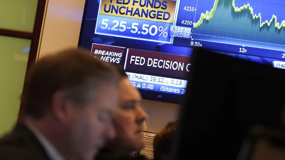 FILE - A television screen shows the rate decision of the Federal Reserve as traders work on the floor of the New York Stock Exchange, Nov. 1, 2023. Inflation has kept slowing, and the economy has withstood the strain of the accumulated higher borrowing costs. On Thursday, Jan. 11, 2024, the Labor Department is expected to report that underlying inflationary pressures eased further in December 2023. (AP Photo/Richard Drew, File)