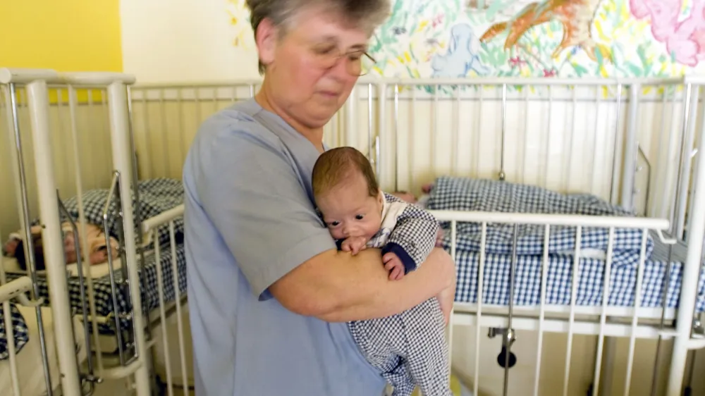 A nurse holds a baby at a center for nutritional recuperation in Timisoara, Romania, 600 kilometers (373 miles) west of Bucharest, Wednesday May 10, 2006. The center, which houses 59 children of which 12 are registered as abandoned is mentioned in a report by an advocacy organization charging Wednesday that Romania warehouses mentally ill children in adult institutions in filthy and degrading conditions. Romanian officials on Wednesday acknowledged problems in caring for disabled and abandoned children, but disputed allegations by a U.S. human rights group of widespread neglect and abuse. (AP Photo/Vadim Ghirda) ROMANIA OUT