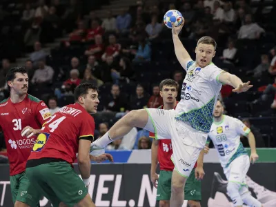 Slovenia's Kristjan Horzen, right, takes a shot during the European Handball Championship main round, Group 2 between Slovenia and Portugal at the Barclaycard Arena, in Hamburg, Germany, Friday Jan. 19, 2024. (Claus Bergmann/dpa via AP)