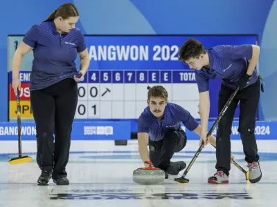 In this photo provided by Olympic Information Services, Owen Robert Nelson, center, of the U.S. releases the stone in the first round of the curling mixed team round robin match against Japan at the Gangneung Curling Centre during the Winter Youth Olympic Games in Gangneung, Gangwon Province, South Korea, Monday, Jan. 22, 2024. (Chloe Knott via OIS)